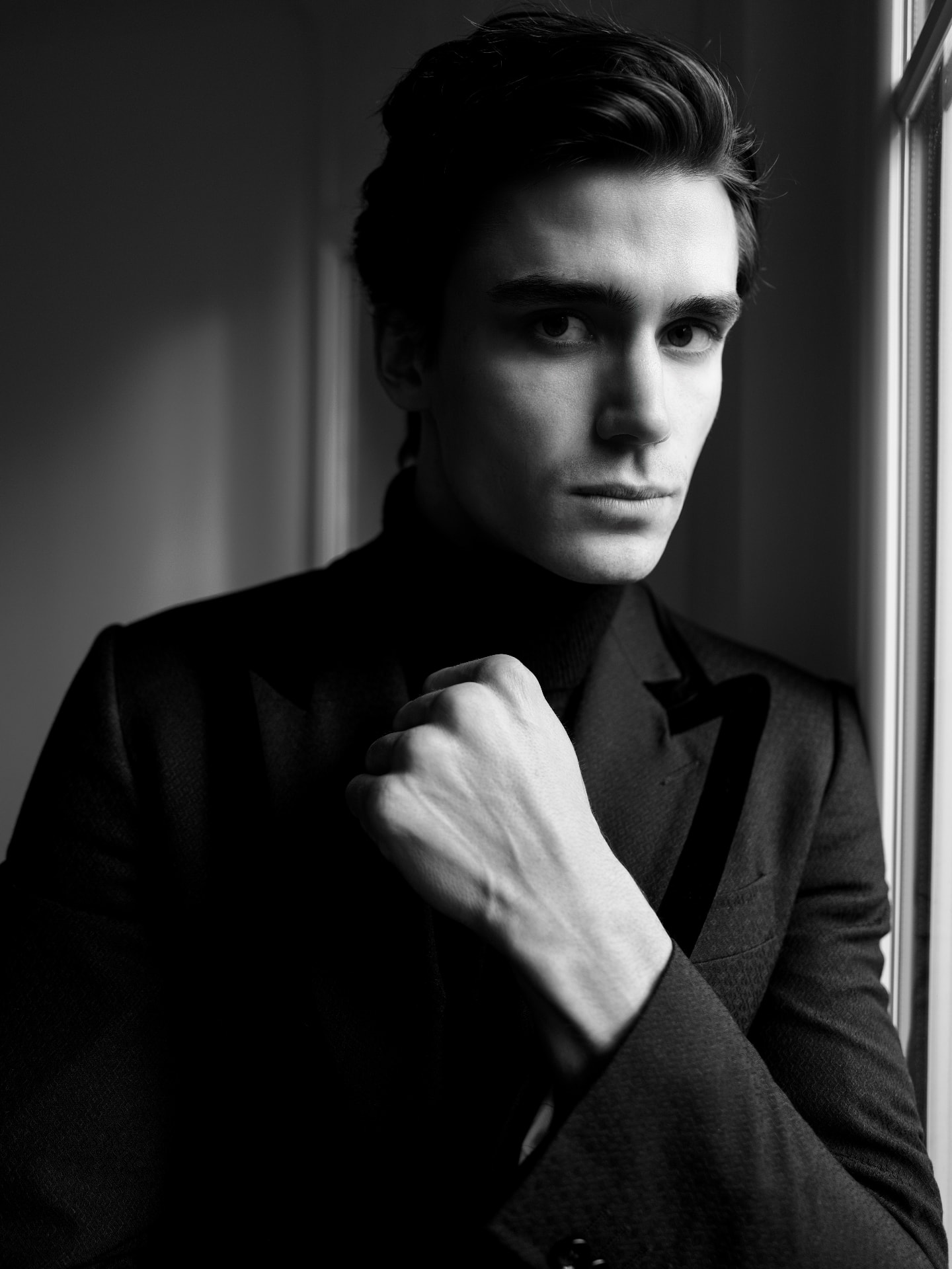 Michal Mrázik photographed by a window in black and white